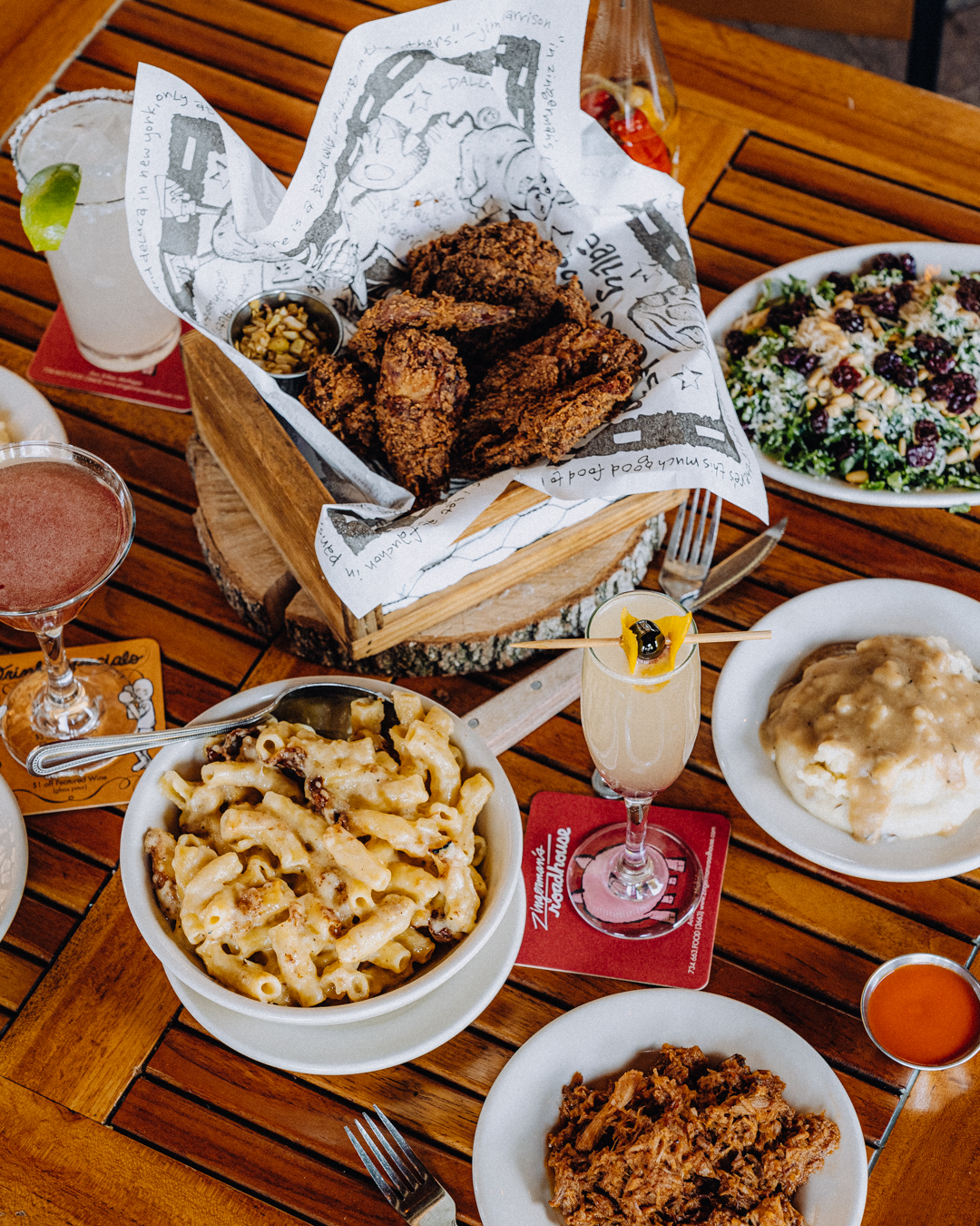 A spread of fried chicken, mac and cheese, salad, mashed potatoes, BBQ, and more